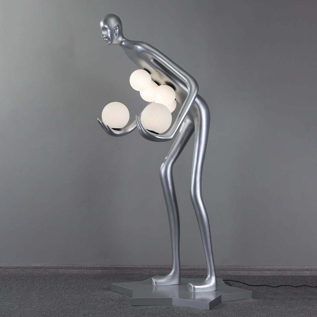 Sculptural floor lamp with silver body holding glowing orbs, perfect for Art Deco style living room lighting.