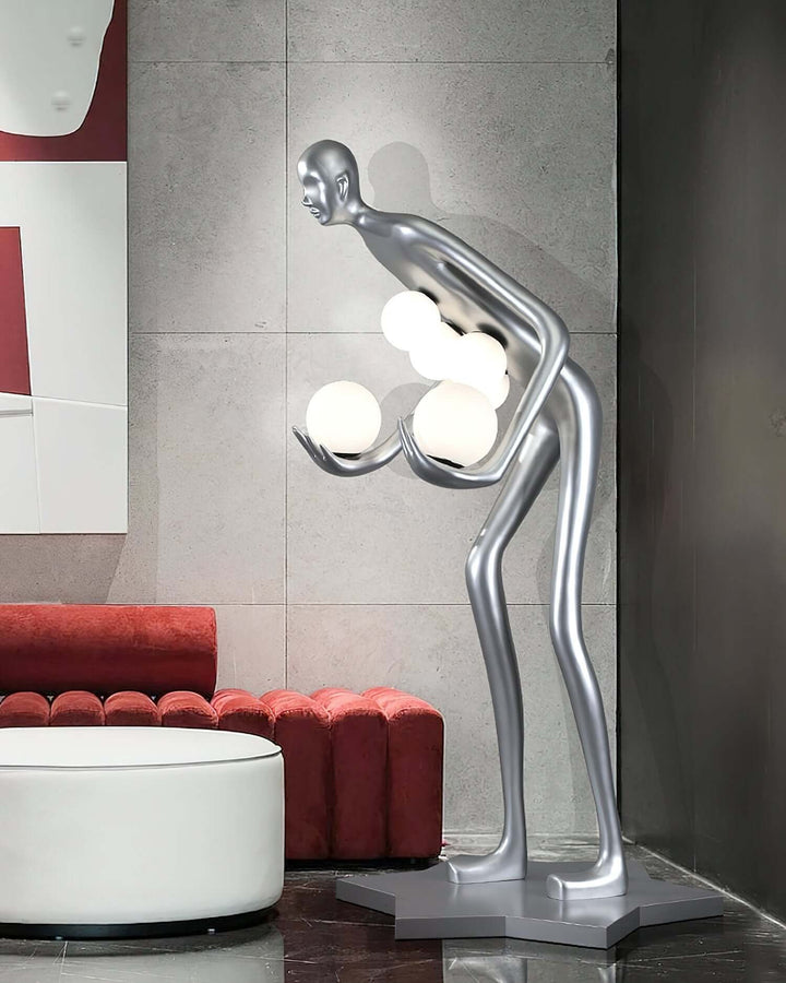 Sculptural Art Deco floor lamp with a silver figure holding glowing orbs, perfect for living room decor.