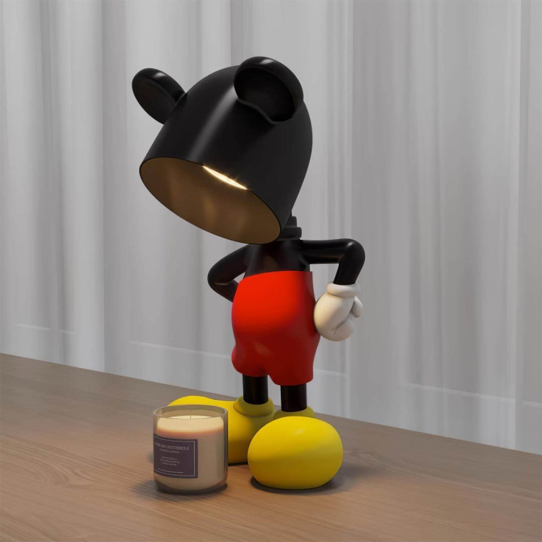 Mickey Table Lamp in black and red, a modern sculptural art deco style lamp beside a lit candle on a wooden table.