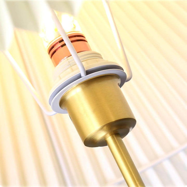 Close-up of the brass socket of a trendy wooden floor lamp, showcasing quality and design for living room decor.