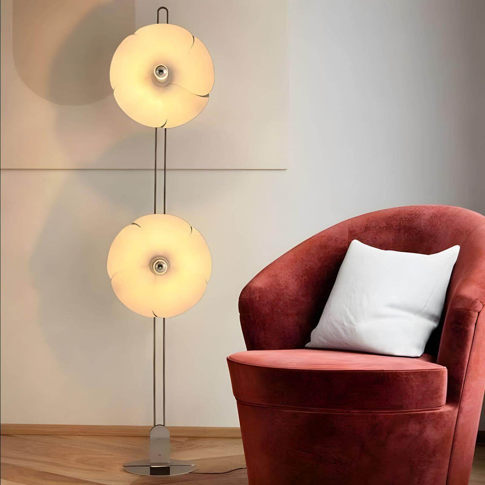 Whimsical Art Deco 2093 floor lamp with two artistic shades, complementing the cozy corner with a plush chair.