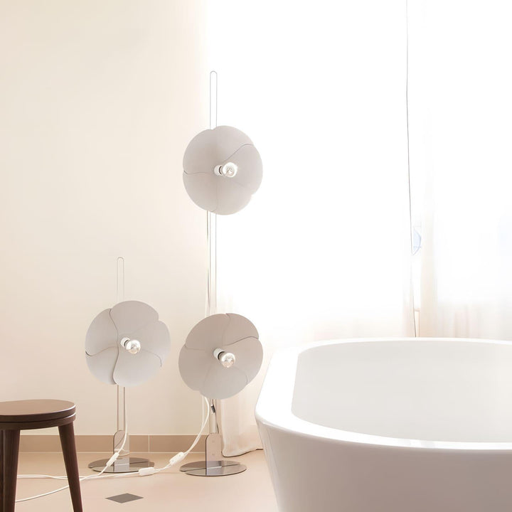 Whimsical Art Deco floor lamp trio in white, illuminating a bright bathroom space with elegant design.