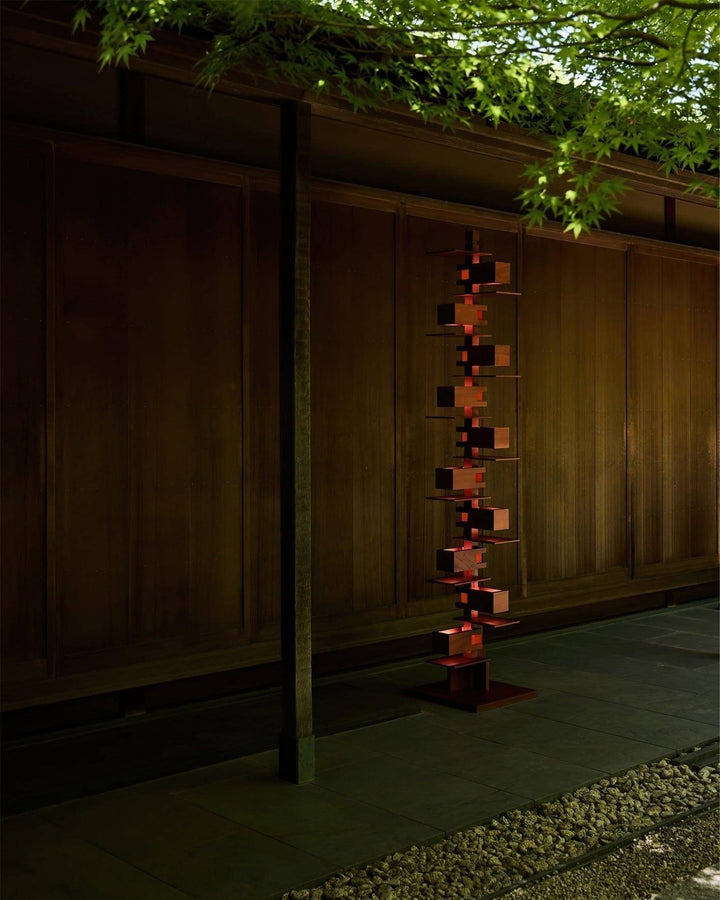 Elegant wooden floor lamp in an art deco style, illuminating a serene outdoor space with modern design.