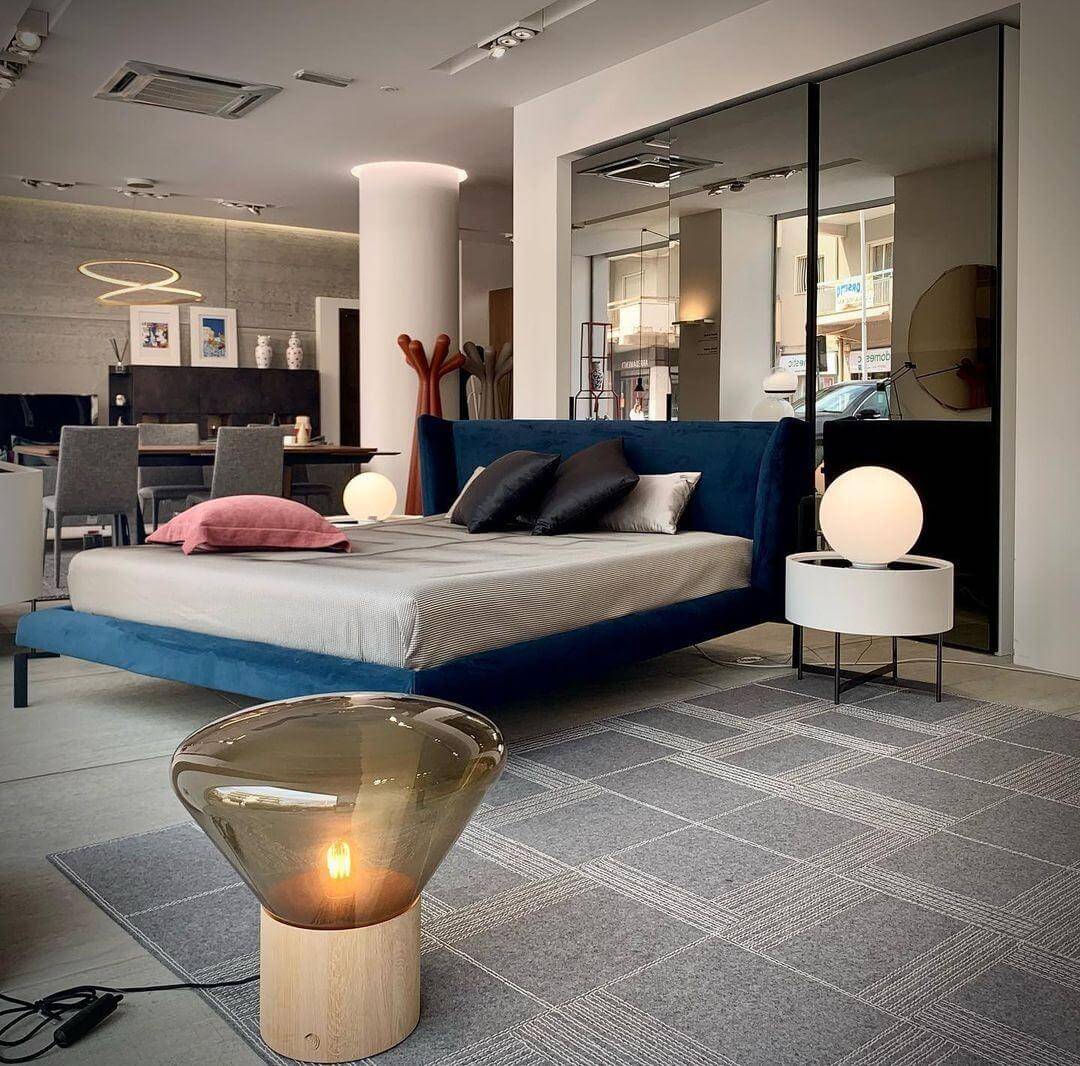 Modern bedroom featuring art deco lamps, round glass table lamps, and contemporary furniture for stylish living.