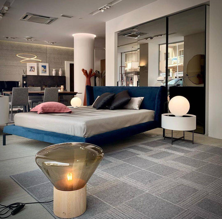 Modern bedroom featuring art deco lamps, round glass table lamps, and contemporary furniture for stylish living.