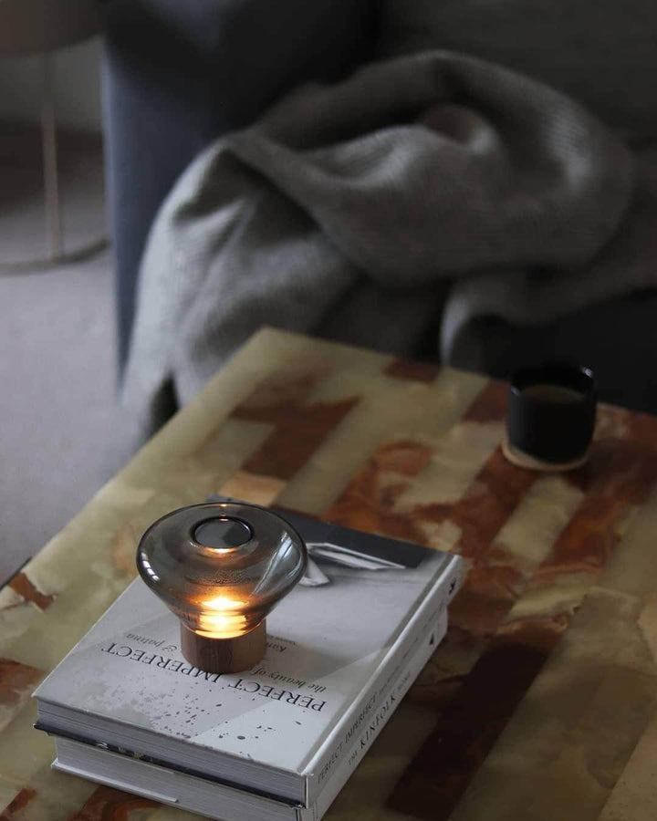 Art deco round glass table lamp on coffee table with books, perfect for modern living room decor.