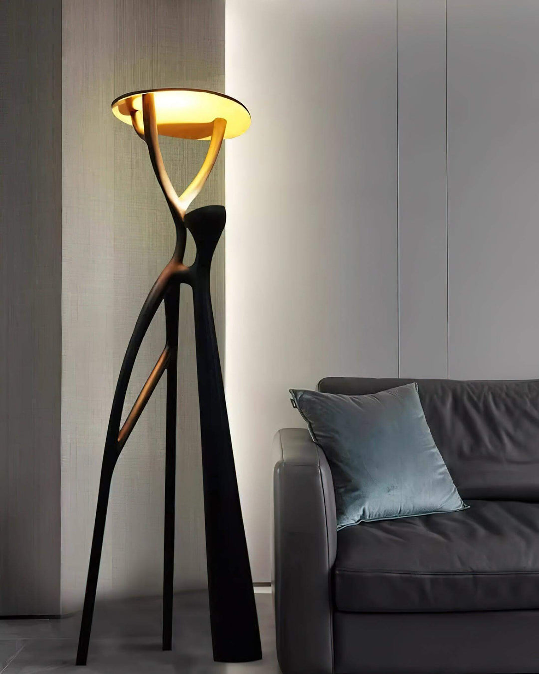 Sculptural art deco floor lamp in black, enhancing a modern living room with soft lighting.