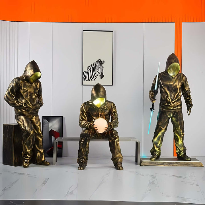 Artistic bronze sculptures of hooded figures, featuring dynamic poses and modern design elements in a contemporary setting.