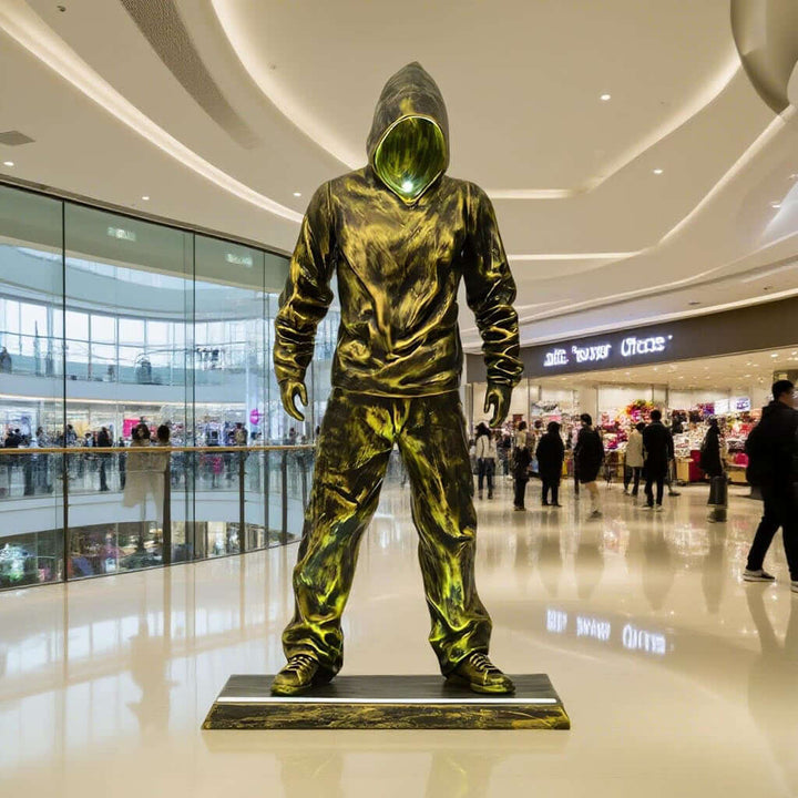 Sculptural figure of an urban hooded man in a shopping mall, reflecting modern artistic style and street culture.