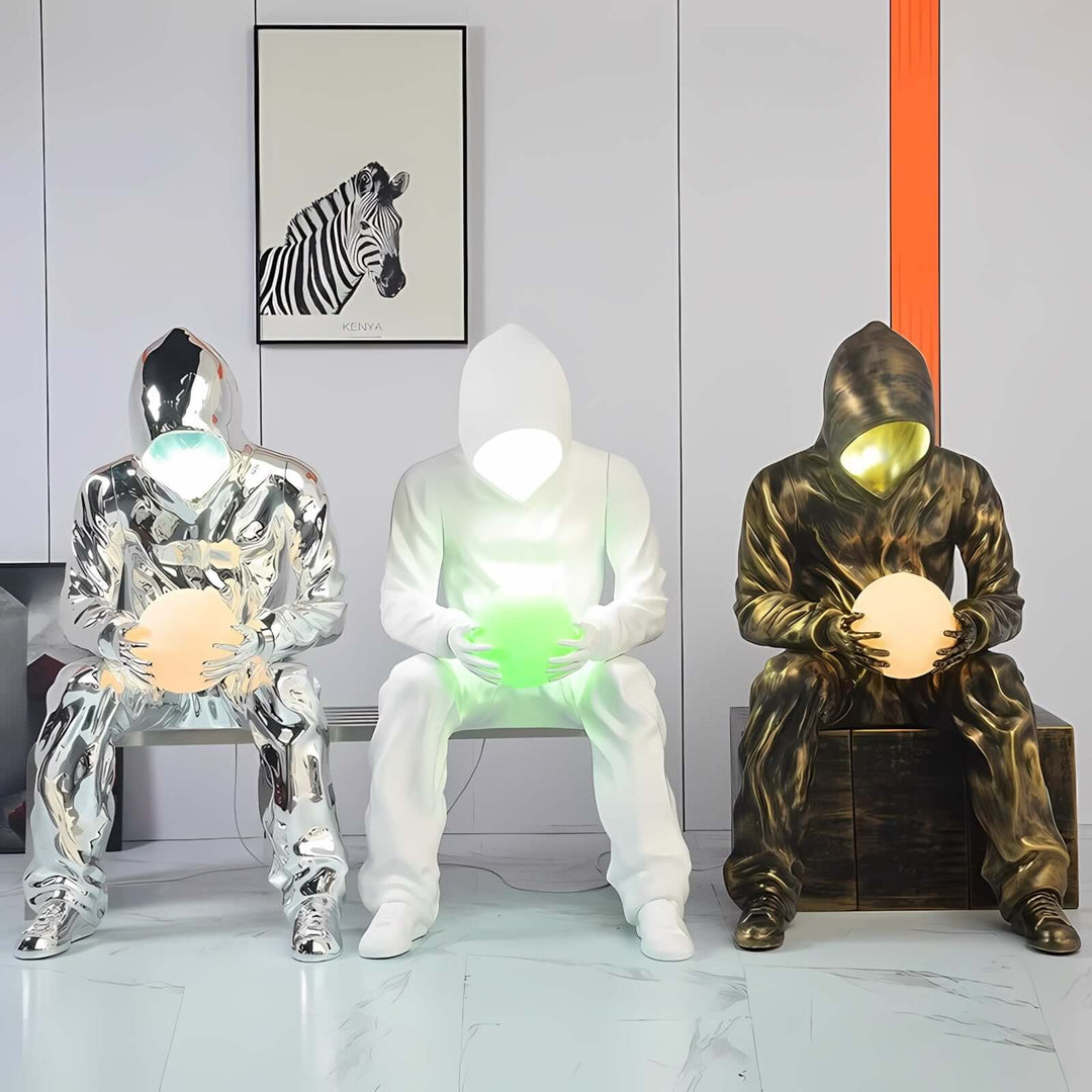 Art deco sculptural floor lamps in modern design, featuring illuminated figures holding glowing orbs.