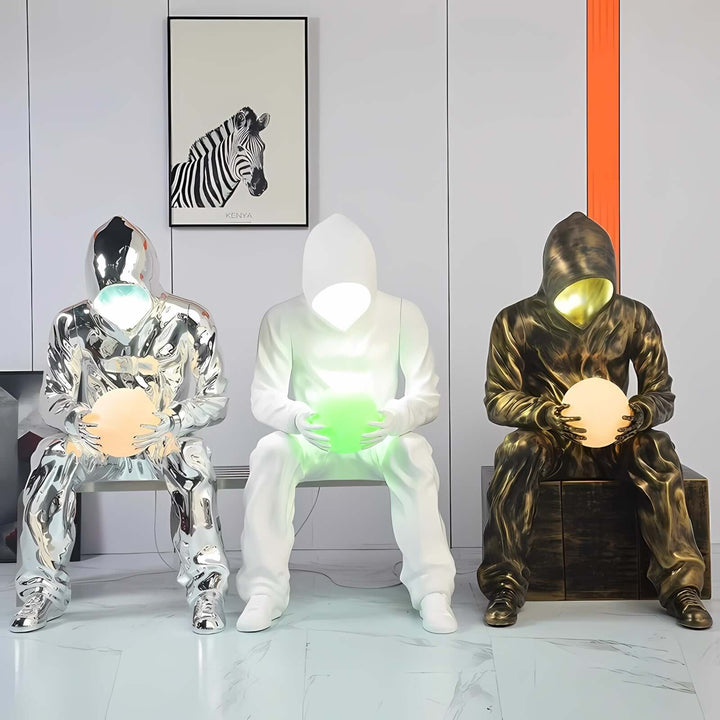 Art deco sculptural floor lamps in modern design, featuring illuminated figures holding glowing orbs.