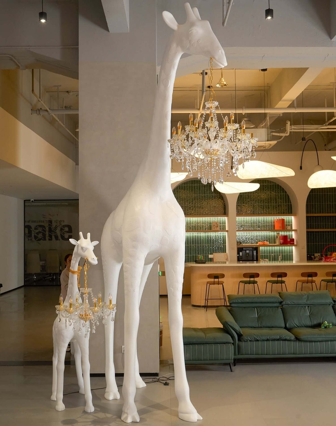 Sculptural giraffe floor lamp with chandeliers in a modern living room setting, adding art deco style.