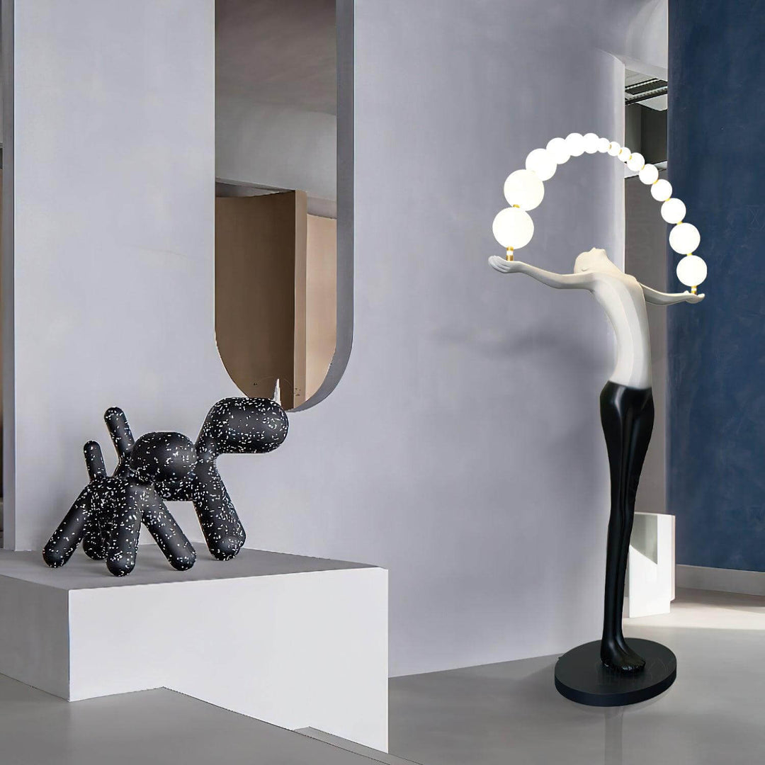 Sculptural floor lamp next to a decorative black dog statue in a modern interior setting.