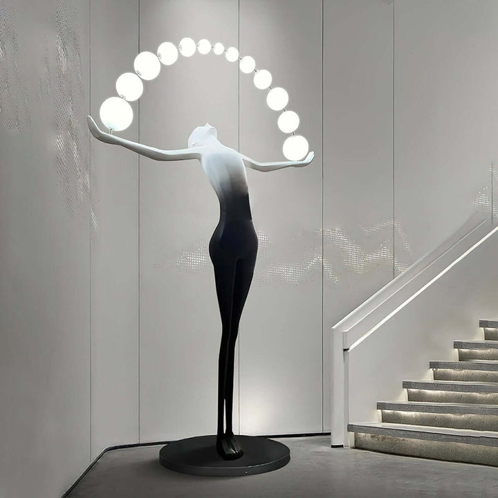 Stylish Olyvra sculptural floor lamp in a modern setting, illuminating a staircase with artistic design.