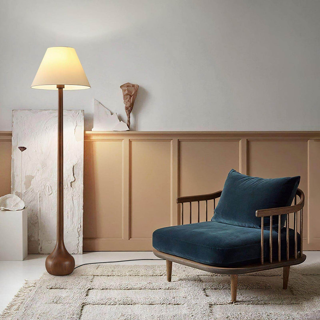 Osaka wooden floor lamp standing next to a cozy blue chair in a stylish living room, perfect for rustic decor.