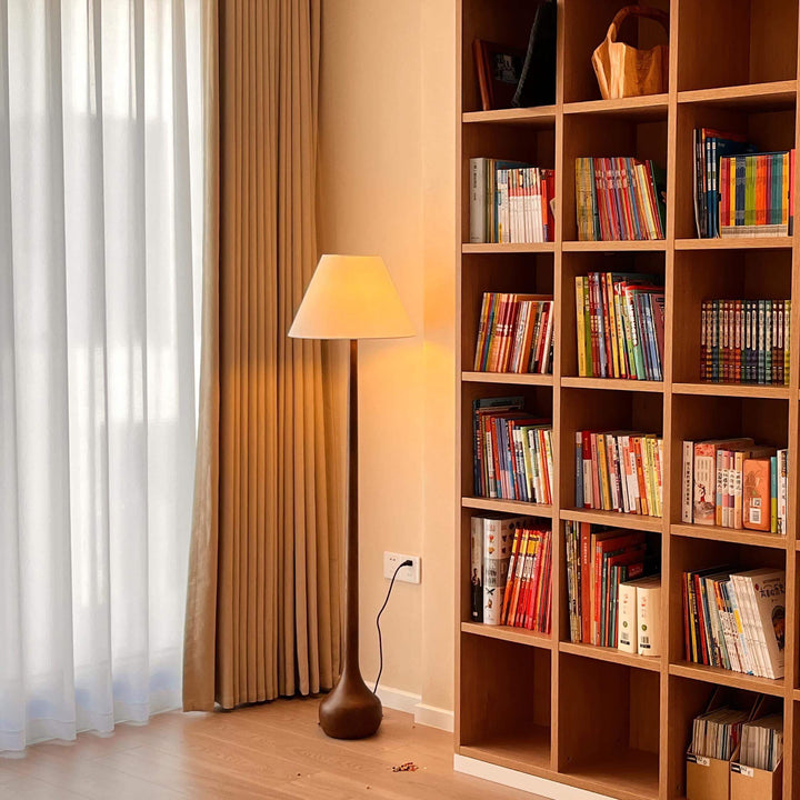 Wooden floor lamp in a cozy living room setting next to a bookshelf, perfect for adding rustic floor lights.