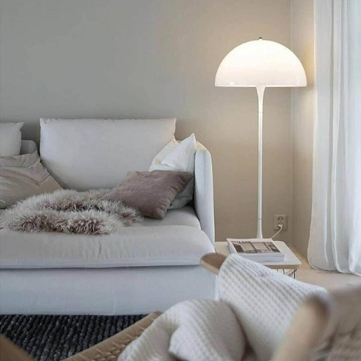 Panthella floor lamp in modern living room, white acrylic design adds elegance and style to cozy seating area.