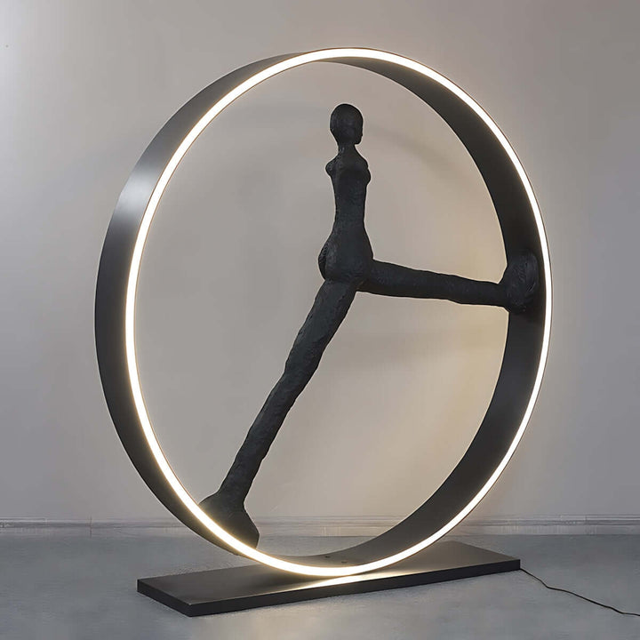 Sculptural floor lamp in art deco style, featuring a unique design with a circular frame and figure, perfect for living room decor.