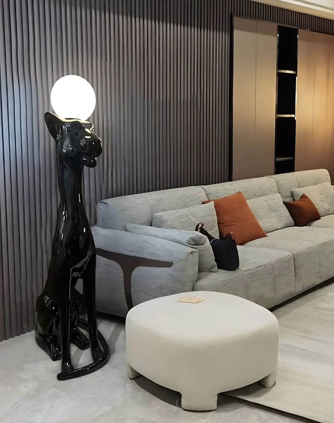Black cat sculptural floor lamp with white globe light in modern living room with gray sofa and round coffee table.