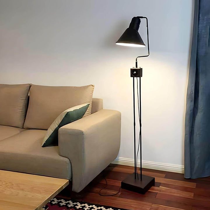Retro Toia Floor Lamp in black next to a modern sofa, ideal as an industrial corner floor lamp for stylish living spaces.