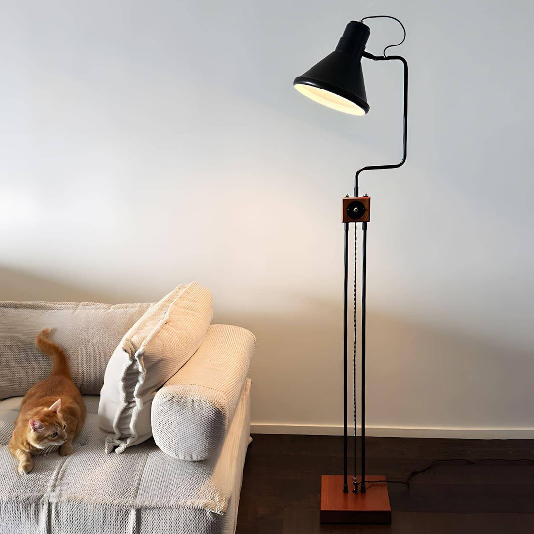 Retro Toia floor lamp in black, an industrial corner floor lamp beside a sofa with an orange cat.