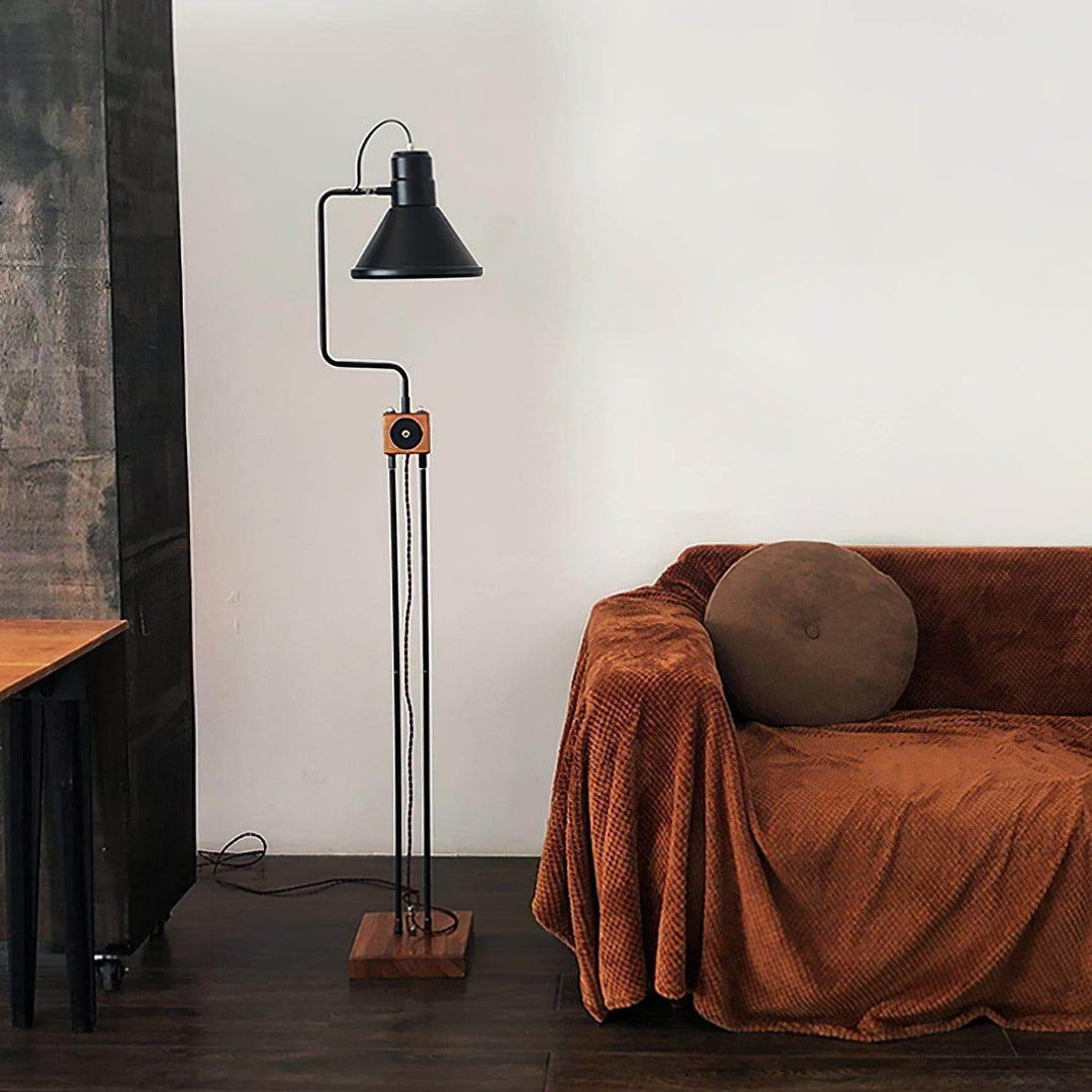 Retro Toia industrial black floor lamp in living room, featuring wood accents and cozy couch.