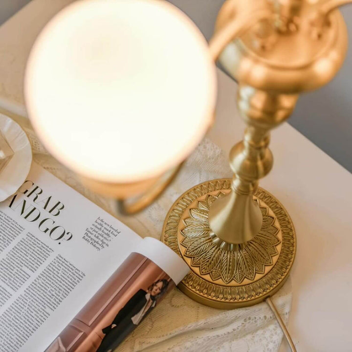 Brass table light casting warm glow over magazine, perfect mid-century modern addition for living room decor.