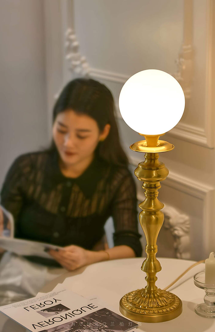 Elegant brass lamp with a white globe, perfect vintage table light for living room decor.