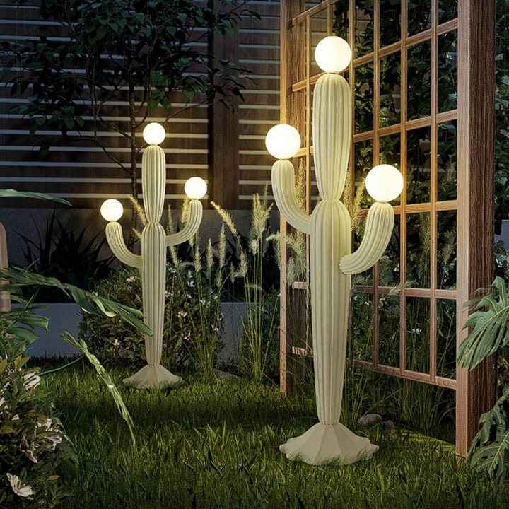Stylish cactus floor lamp in garden setting, featuring a sculptural design with glowing globes, ideal for art deco decor.