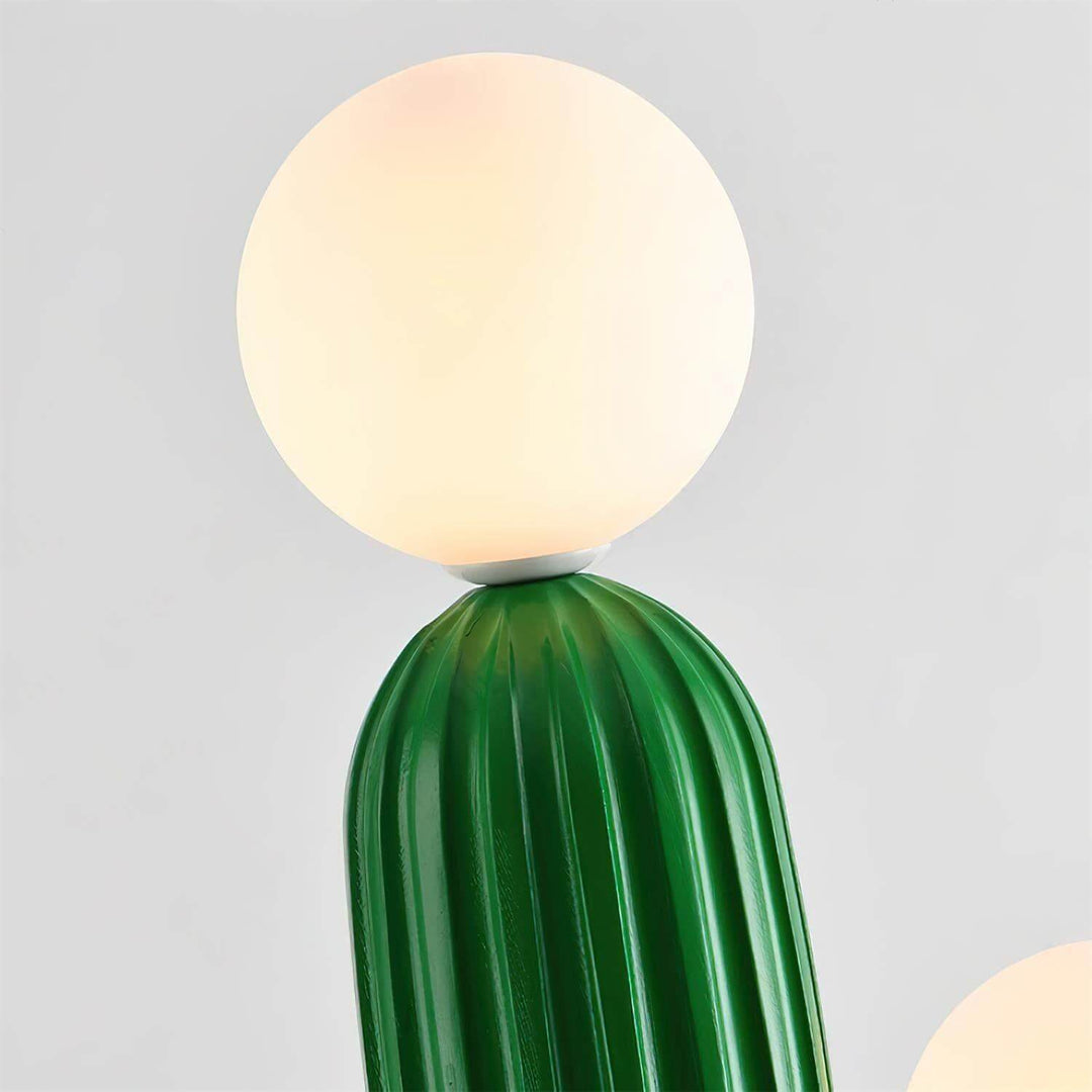 Sculptural green cactus floor lamp with round white globe, perfect for art deco inspired interiors.