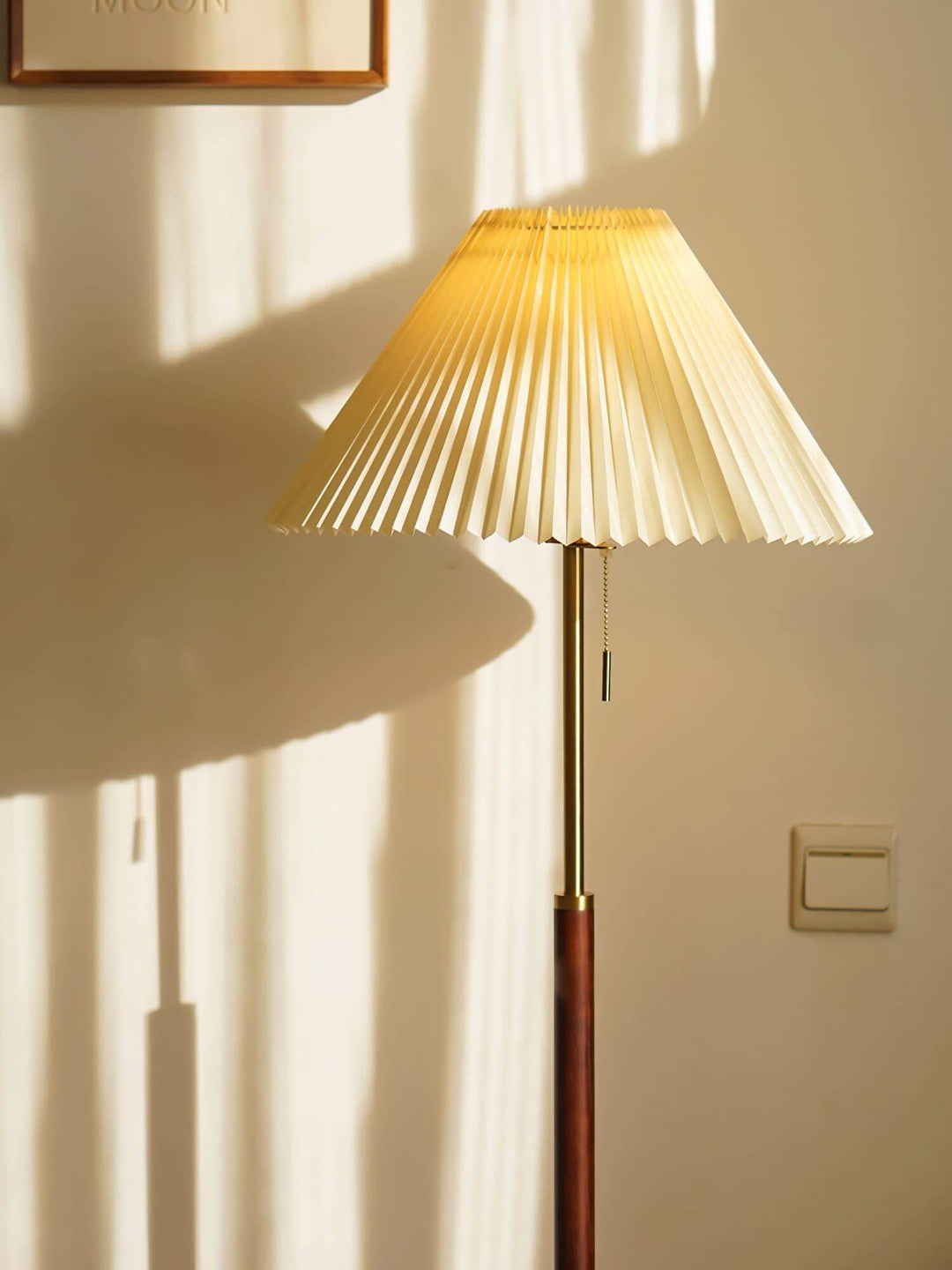 Suki Pleated Floor Lamp, a mid century modern wooden floor lamp casting soft shadows in a cozy corner.