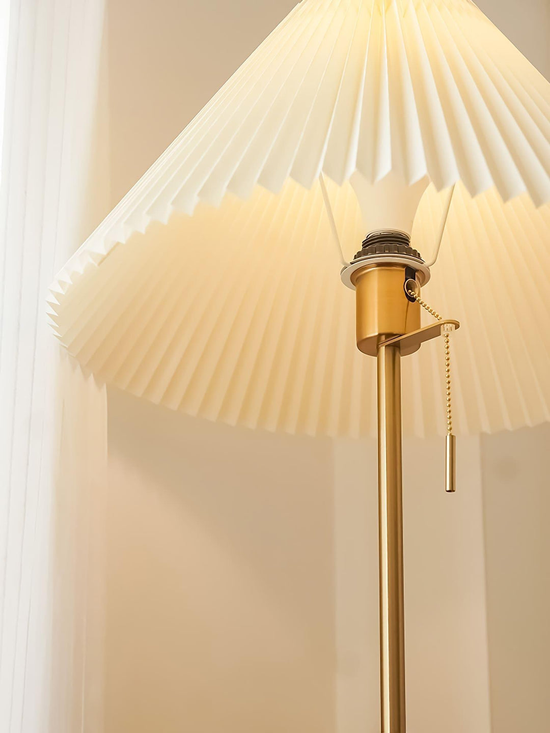 Suki Pleated Floor Lamp featuring a pleated shade and golden base, ideal as a wooden and mid century modern behind sofa lamp.