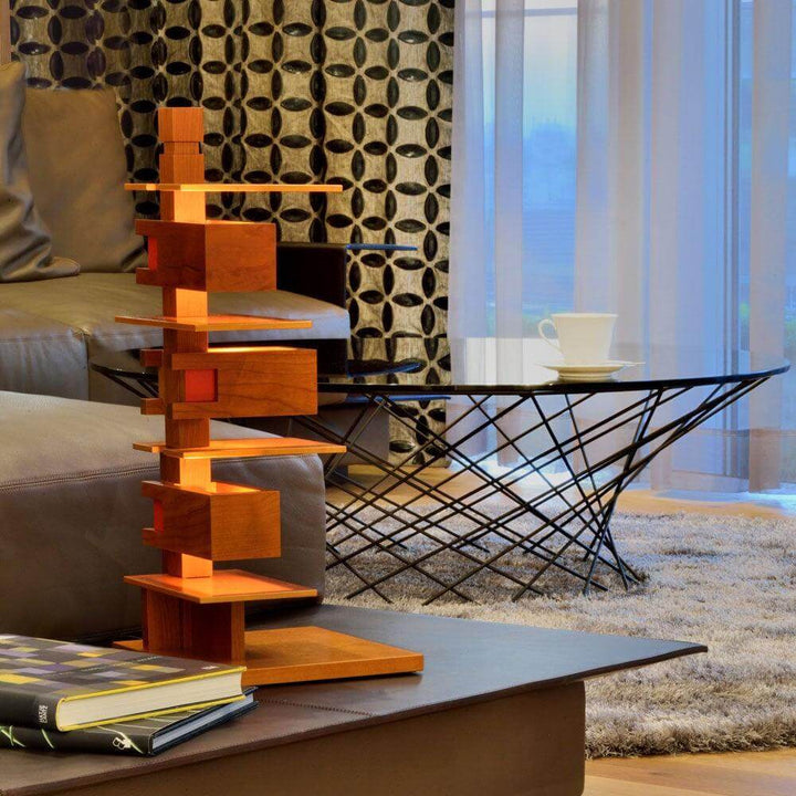 Taliesin table lamp in living room setting, showcasing unique art deco style with wood base and accent lighting.