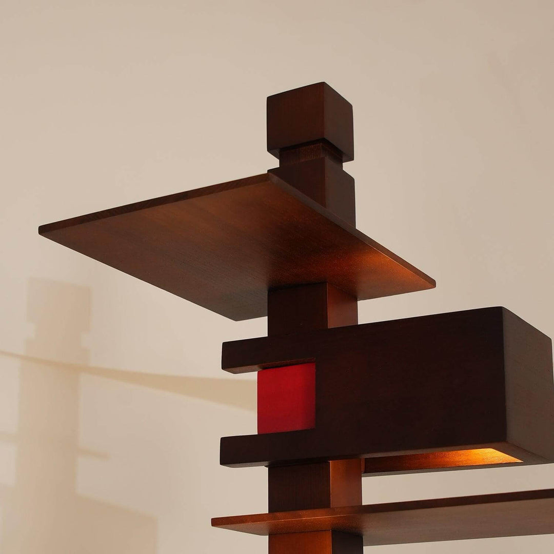 Taliesin wood table lamp design with art deco style, featuring layered wooden shapes and a splash of red accent.
