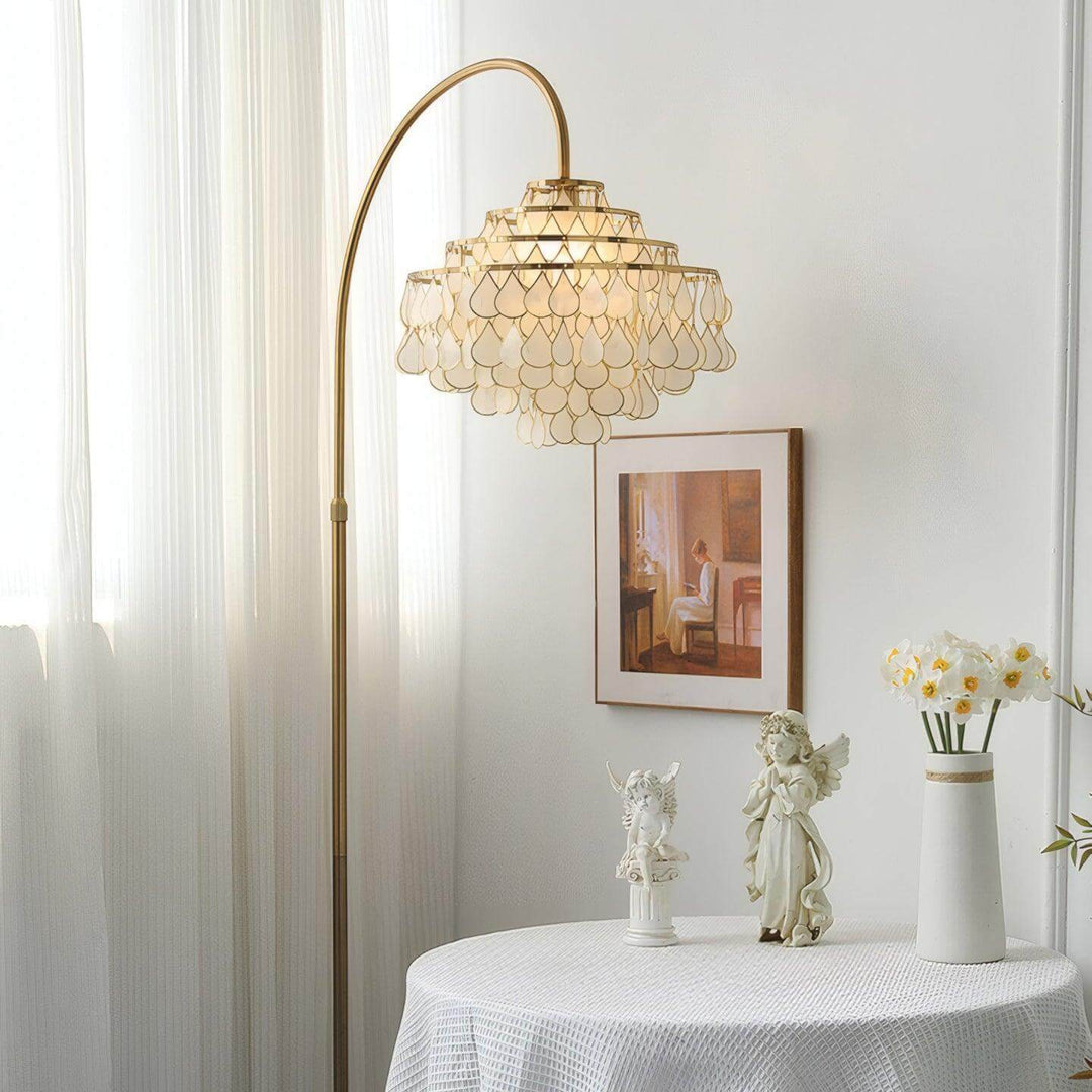Coastal Teardrops Shell Arc Floor Lamp with decorative light in stylish bedroom setting.