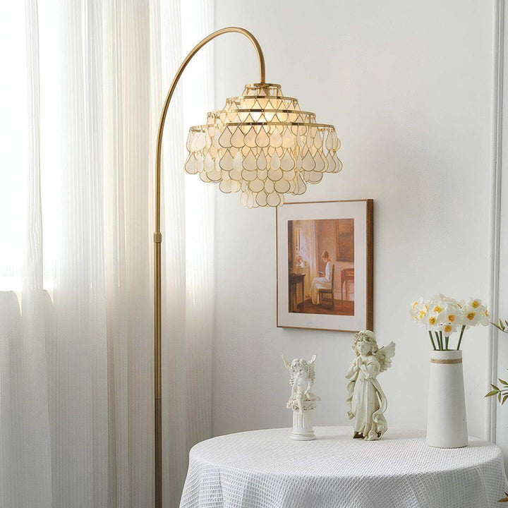 Coastal Teardrops Shell Arc Floor Lamp with decorative light in stylish bedroom setting.