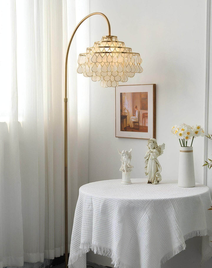 Coastal Teardrop Shell Arc Floor Lamp illuminating a cozy bedroom with elegant decor.