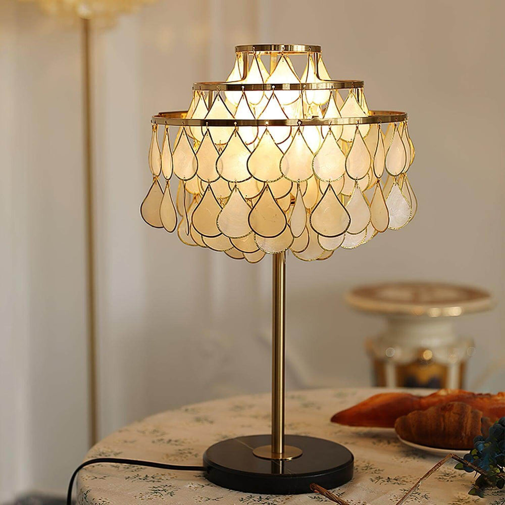 Teardrop shell table lamp with brass accents, perfect for coastal bedside lighting and adding luxury to any decor.