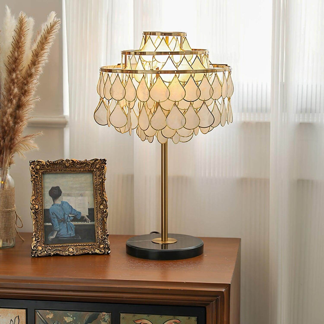 Brass teardrop shell table lamp, luxury coastal bedside lighting for elegant interior decor.