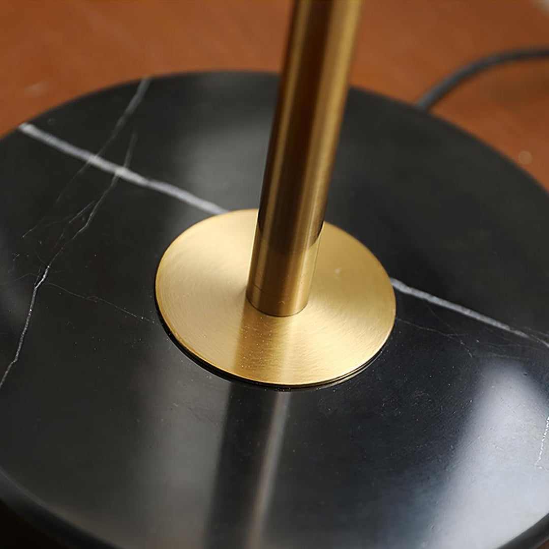 Close-up of brass table light base on black marble surface, showcasing luxury and elegant design for coastal bedside lamps.
