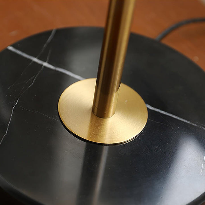 Close-up of brass table light base on black marble surface, showcasing luxury and elegant design for coastal bedside lamps.