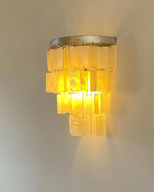 Elegant tiered shell wall sconce, coastal bedside wall light with warm illumination, perfect for stylish décor.