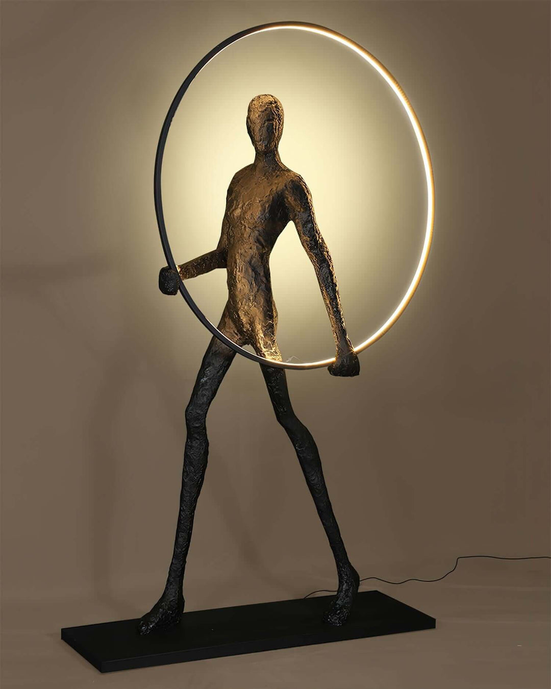 Sculptural floor lamp resembling a human figure holding a circular light, perfect for art deco and modern living room decor.