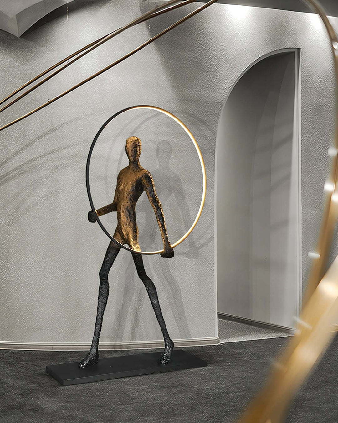 Sculptural floor lamp in an art deco style featuring a walking figure with a circular hoop, elegantly designed for modern interiors.