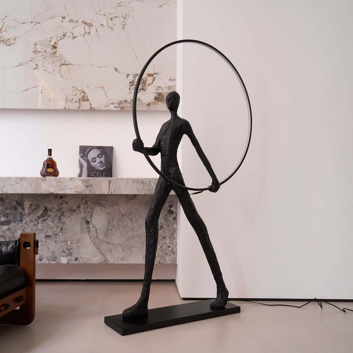 Sculptural art deco Tivoro Ring floor lamp in modern living room setting.