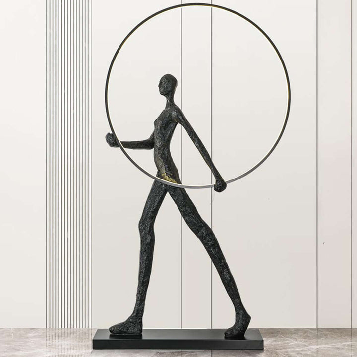 Sculptural floor lamp featuring a modern figure holding a circular hoop, perfect for art deco decor.