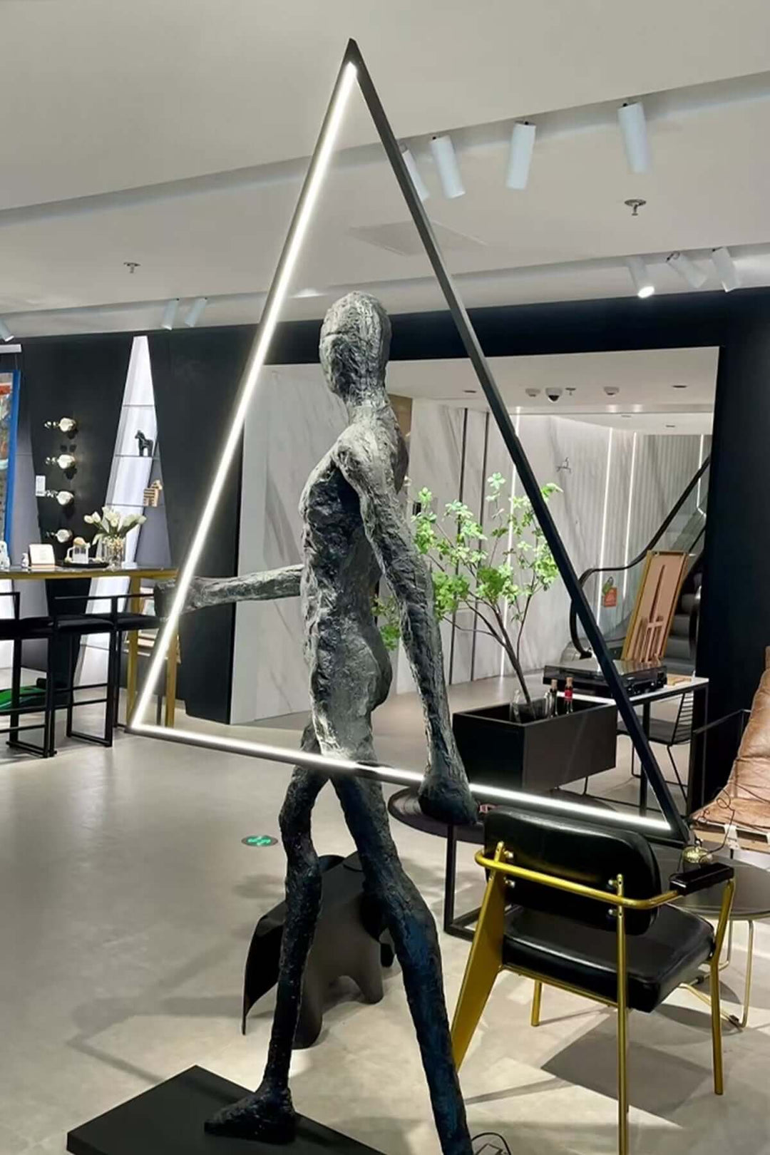 Tivoro Triangle Floor Lamp in living room, showcasing a resin sculpture and Art Deco style.