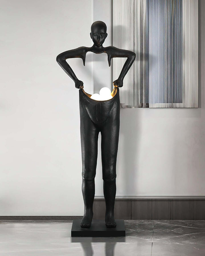 Sculptural floor lamp in art deco style, featuring a unique human form design in a contemporary living room setting.