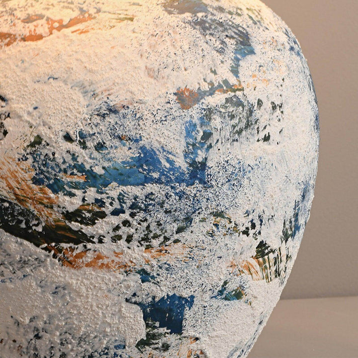 Close-up of a textured ceramic vase featuring blue and white abstract patterns, adding artistic flair to any decor.
