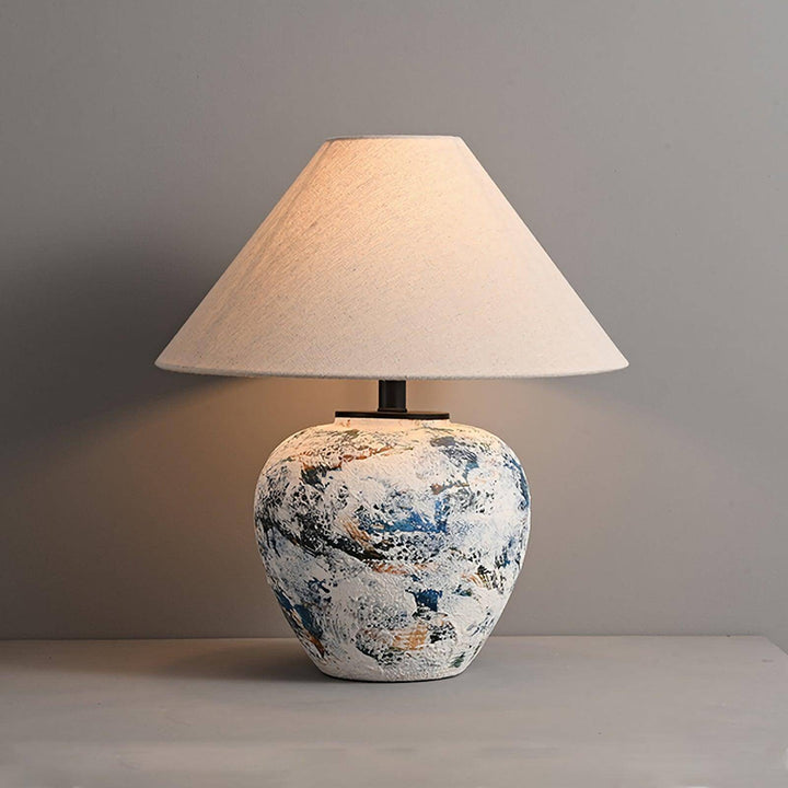 Neoclassical ceramic table lamp with a textured base and fabric shade, ideal for farmhouse table decor.